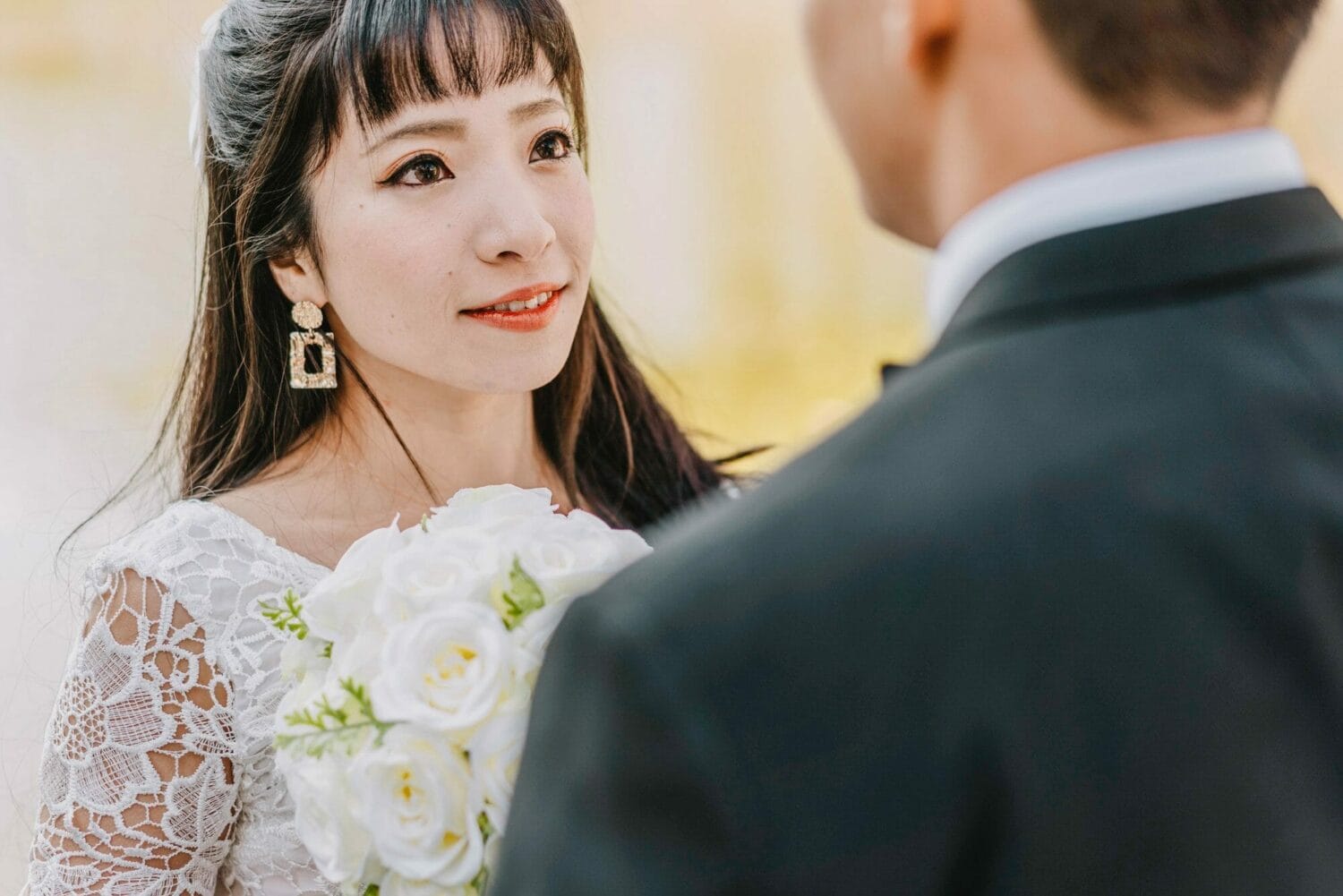 beautiful-bride-looking-into-groom-s-eyes-while-holding-bouquet